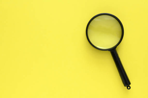 istock Black magnifier on a yellow background. 1392700025
