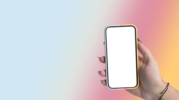 istock Woman hand holding smart phone  isolated on gradient colorful pastel background. Empty display for graphic display montage. 1392700888