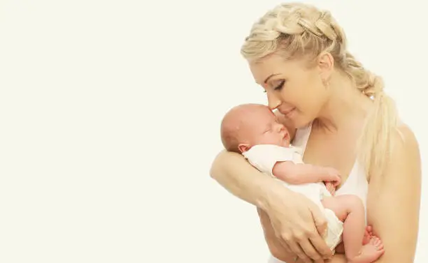 Baby sleeping on mother's hands on white background