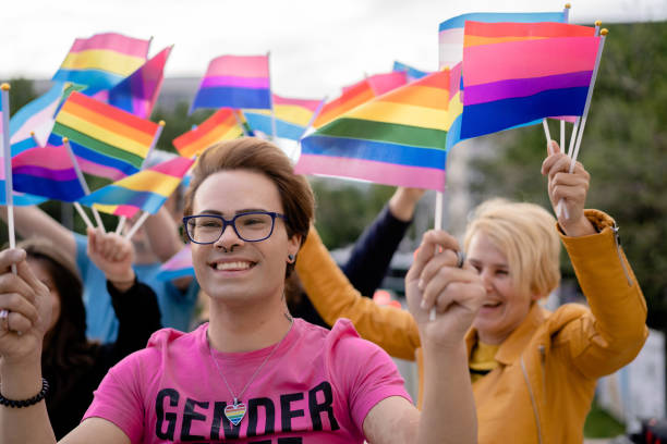 istock Trangender man with different LGBTQ+ flags on a pride event 1392701292