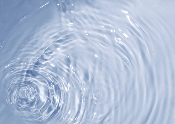 istock Circles on water. Blue round shadows. Blurred background made with water and light in monochrome. 1392701989