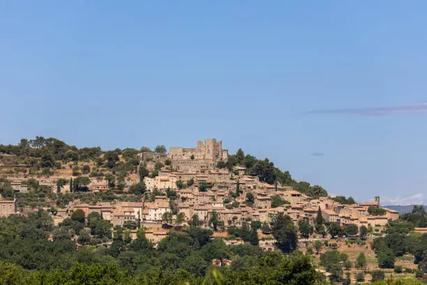 Photo of Medieval historic Lacoste village stands on hilltop of Little Luberon massif with ruins Marquis de Sade castle. Vaucluse, Provence, France