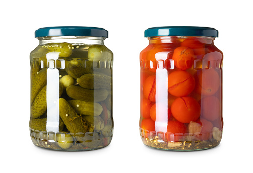 The two glass jar with cucumbers and tomatoes on a white background