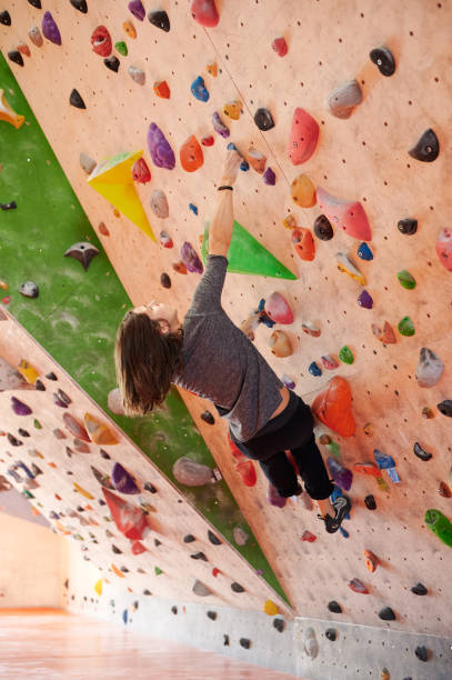 istock Female climber hanging on angled wall 1392704501