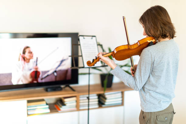 istock Boy learning to play violin with teacher online 1392708457