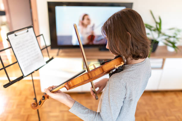 istock Boy learning to play violin with teacher online 1392708488