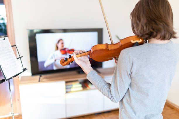 istock Boy learning to play violin with teacher online 1392708530