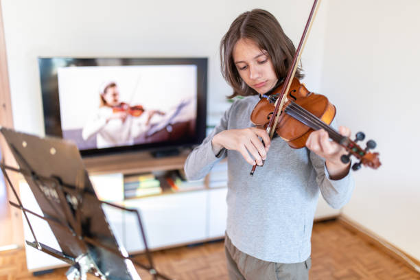 istock Boy learning to play violin with teacher online 1392708533