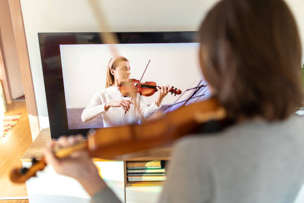 istock Boy learning to play violin with teacher online 1392708560