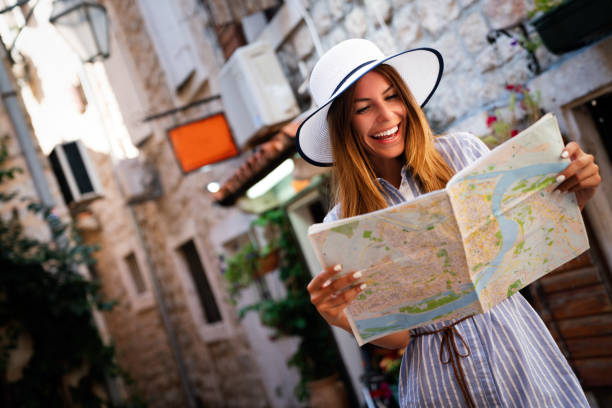 istock Young female tourist with map looking for a way on summer vacation 1392711471