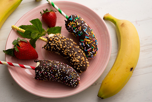 Chocolate dipped bananas. French delicatessen dessert.