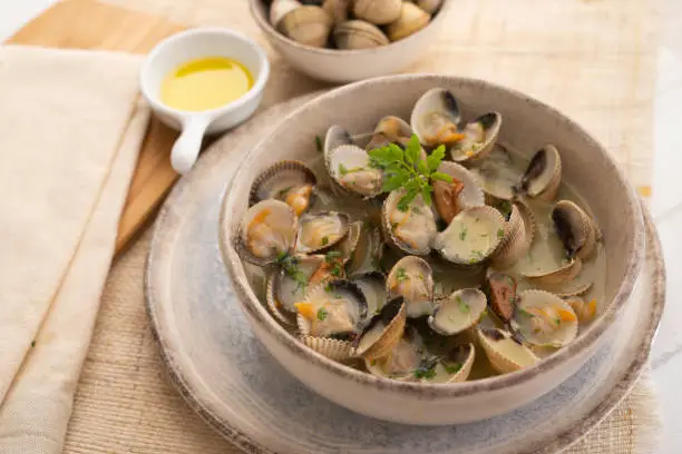 Cockles cooked in green sauce. Traditional Basque country recipe. Spanish cover.