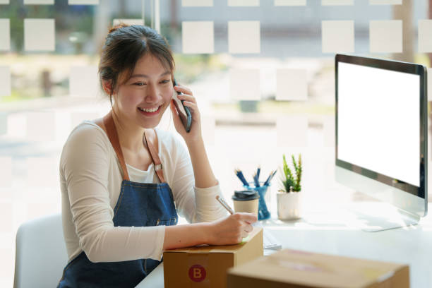 istock Asian small business owner with packing parcel box at home office, SME e commerce concept. 1392713090