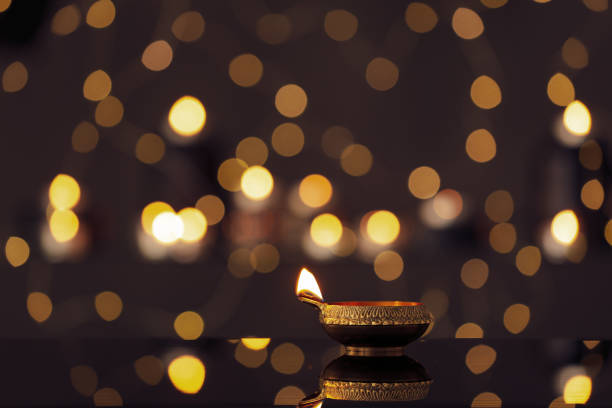 istock Lit diya on table against blurred lights, space for text. Diwali lamp 1392713155
