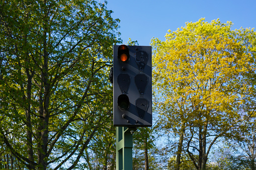 Orange light at a railway signal indicates trains to slow down