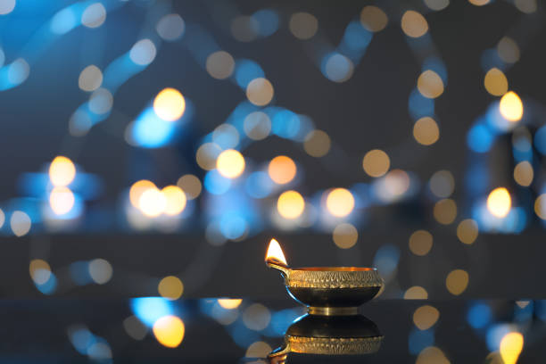 istock Lit diya on table against blurred lights, space for text. Diwali lamp 1392714247