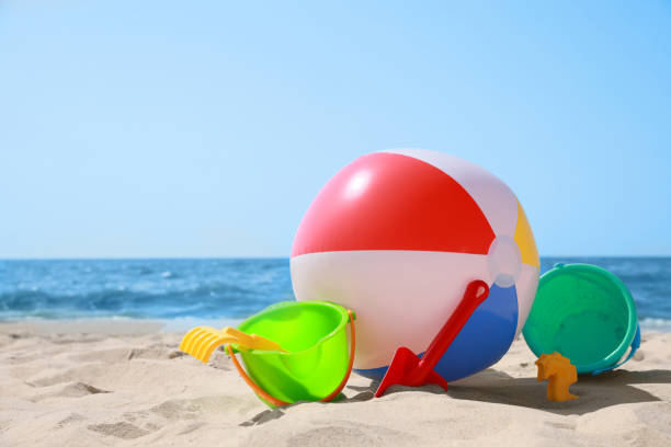 istock Different sand toys and beach ball near sea 1392714321