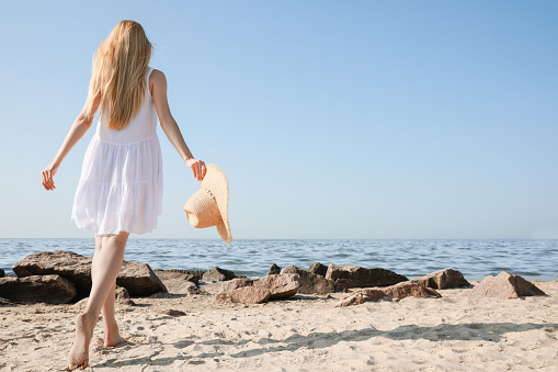 Soot of young beautiful sexy woman sitting on the beach over sea background