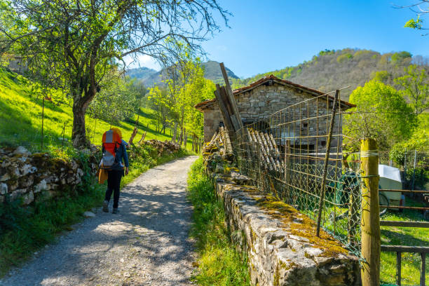 istock A young mother with a backpack walking along the Sella river between El Tornin a la Olla de San Vicente, near Cangas de Onis. Asturias. Spain 1392715681