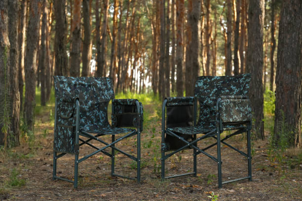 istock Camouflage chairs in forest on sunny day 1392715778