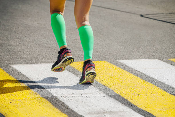istock legs girl runner in bright green compression socks 1392715842