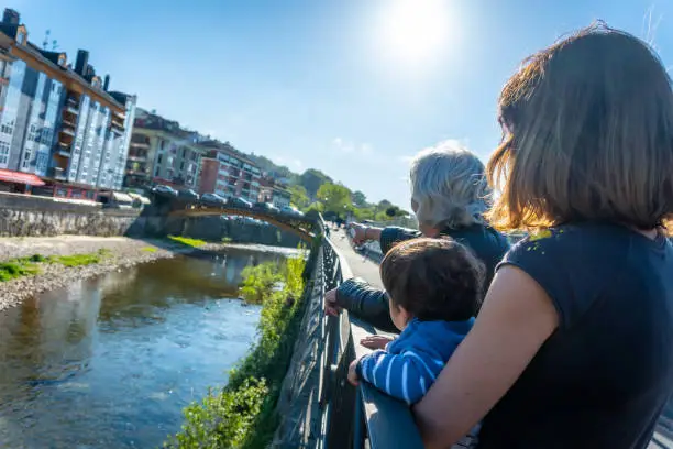 A family looking at the Sella river in the town of Cangas de Onis. Asturias. Spain
