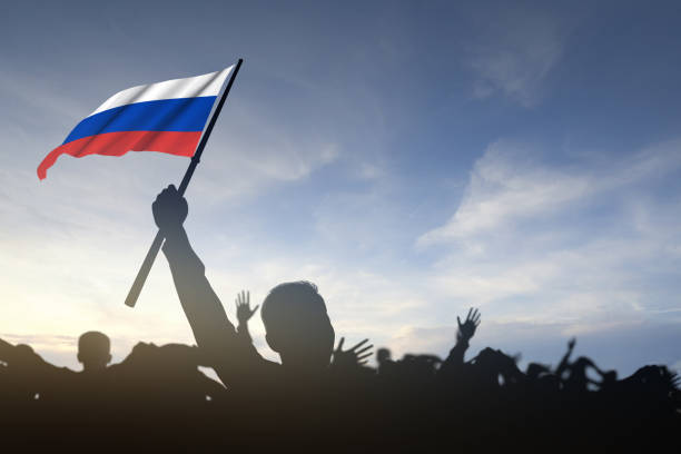 istock Silhouette of crowd people holding Russian flag 1392716763