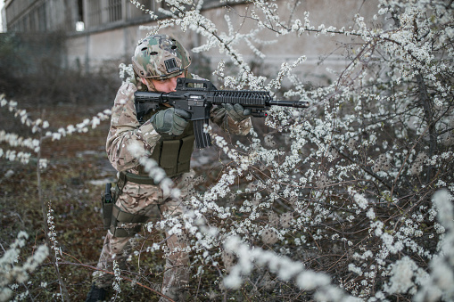 Special forces soldier wearing camouflage uniform armed with weapons in conflict war zone