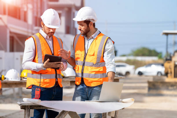 istock Engineer and architect discussing building plan at construction site,Group of builders having conversation about building plan. 1392719975
