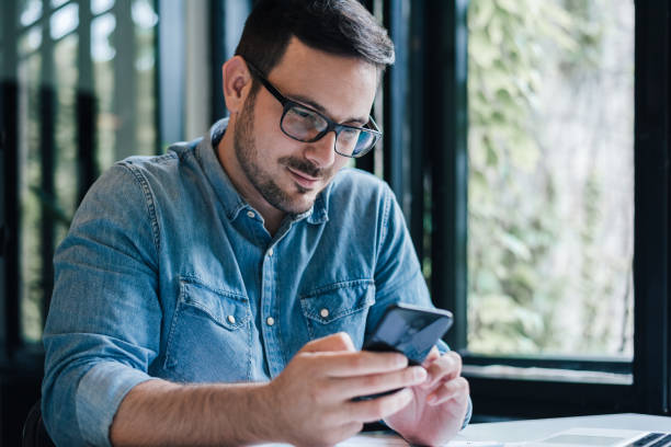 istock Confident male professional text messaging on mobile phone at table 1392720079