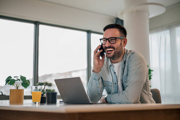 istock Cheerful business professional talking on mobile phone while working at office 1392720322