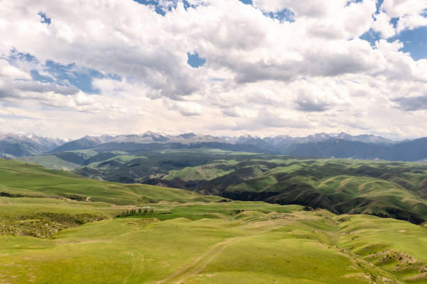istock Mountain peaks and grassland are under white clouds. 1392720366