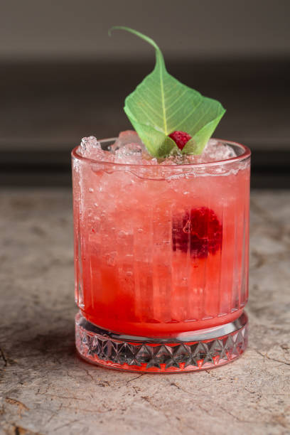 istock Glass with strawberry mojito cocktail with lemon and mint, cold refreshing drink or beverage with ice on gray background 1392720595