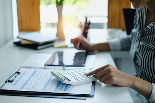 Close up Business woman hand using calculator to calculate the company's financial results and budget. Account Audit Concept