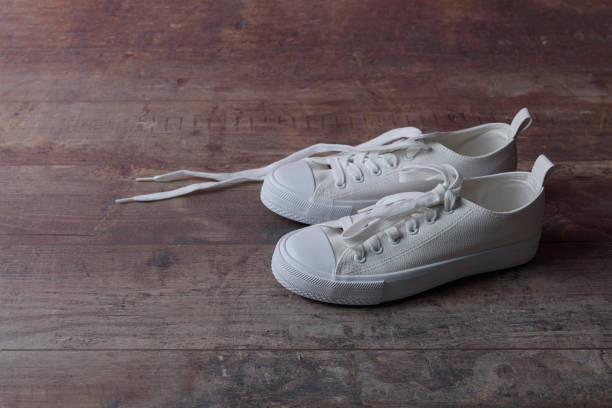 istock White children sneakers on a old textured wood background 1392723012