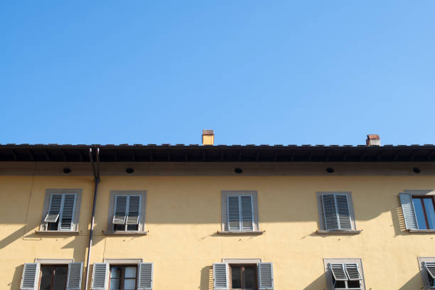 yellow building with shuttered windows against the blue sky