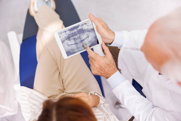 Doctor showing jaw x-ray to patient stock photo