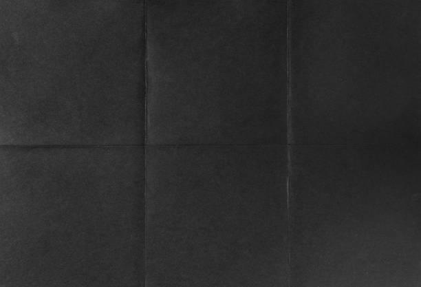 Black crumpled unfolded paper sheet texture background stock photo