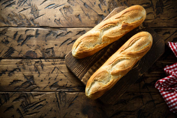 Baguette Traditional homemade baguette bread on a wooden desk baguette stock pictures, royalty-free photos & images