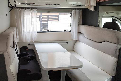 Table and seats  of a mobile home with safety chairs for the children, ready to travel