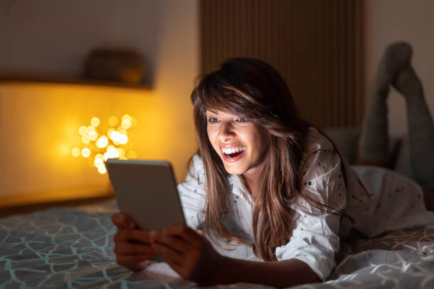 istock Woman reading an ebook in bed at night 1392728459