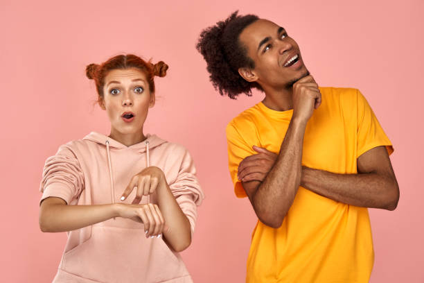 istock Glad dark skinned guy focused up, shocked ginger woman indicates at time, being in hurry 1392728527