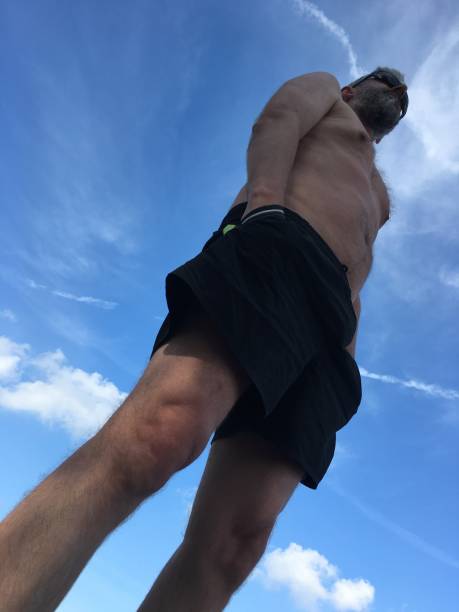 Low angle view of a man on the beach with blue sky in the background