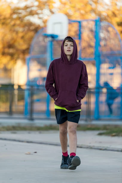 istock Front view of a young hooded boy walking away 1392731701