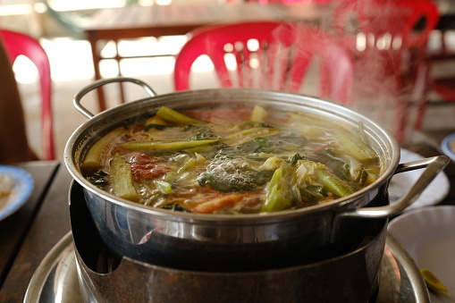 Close up shot of the pot of boiling soup on a restaurant table in Vietnam. Hot Pot. Cooking food Theme. Asian seafood delicious. High quality photo