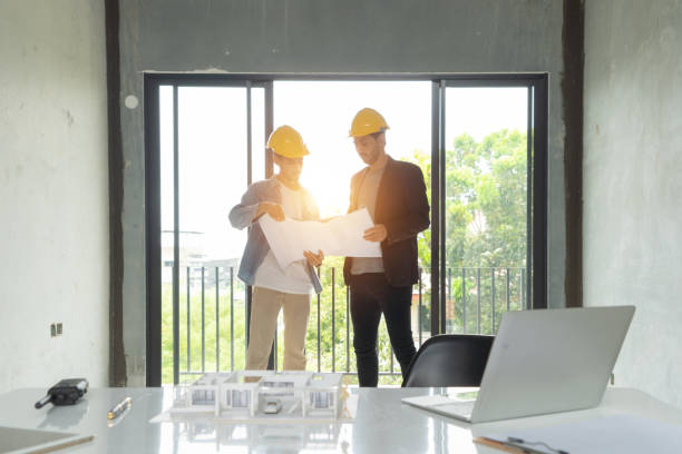 istock A group of workers, a designer team talk, communicate, discuss, and work in meeting room on construction site, present ideas to colleagues. People lifestyle. Corporation. Men 1392732456