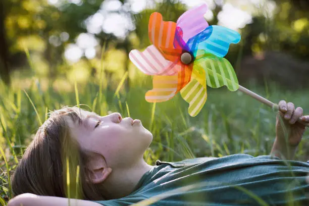 Portrait of a cute child with rainbow pinwheel toy.