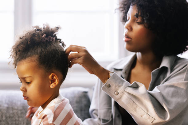 istock Mother Tying Her Daughter's Hair 1392735663