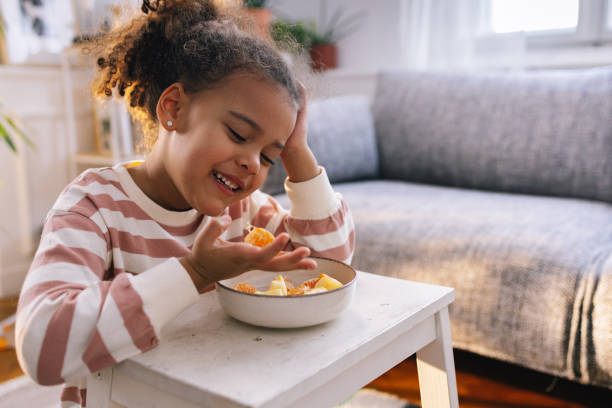istock Afro-American Girl Eating Fruit 1392735688