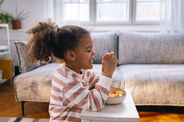 istock Afro-American Girl Eating Fruit 1392735690